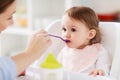 Happy mother feeding baby with puree at home Royalty Free Stock Photo