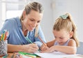 A happy mother, girl child drawing on paper and coloring together with pencils for preschool homework. Children in Royalty Free Stock Photo