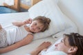 Happy mother and girl daughter waking up on bed at morning together.Happy relaxed parents enjoying life with their Royalty Free Stock Photo