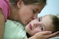 Happy mother gives her son a kiss before sleep and wish good night and beautiful dreams Royalty Free Stock Photo