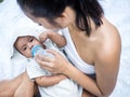 Happy mother giving her baby boy bottle of milk in her arms, Healthcare and medical love Royalty Free Stock Photo