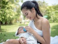 Happy mother giving her baby boy bottle of milk in her arms, Healthcare and medical love Royalty Free Stock Photo