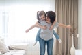 Happy mother giving joyful piggyback ride to her daughter, having fun at home, single mother happy family concept Royalty Free Stock Photo