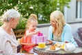 Happy mother giving present to daughter at cafe Royalty Free Stock Photo