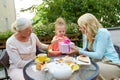 Happy mother giving present to little daughter at cafe Royalty Free Stock Photo