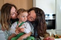 Happy mother and grandmother kissing small baby indoors at home. Royalty Free Stock Photo