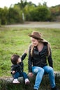 A happy mother in a hat emotionally tells something of her baby