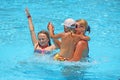 Happy mother having fun jumping with her daughters in swimming pool Royalty Free Stock Photo