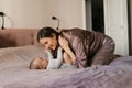 Happy mother having fun and laughing with her baby on the bed Royalty Free Stock Photo