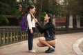 Happy mother helping her little daughter to zipper jacket before school outdoors