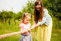 Happy mother helps her daughter playing tug of war Royalty Free Stock Photo