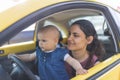 Happy mother and her adorable baby in yellow compact car Royalty Free Stock Photo