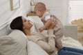 Happy young mother with her baby on sofa in living room Royalty Free Stock Photo