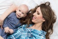 Happy mother and her baby son lying on a bed together. Happy family. Mother and newborn child. Royalty Free Stock Photo