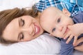 Happy mother and her baby son lying on a bed together. Happy family. Mother and newborn child. Royalty Free Stock Photo