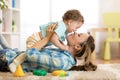 Happy mother with her baby having fun pastime on the carpet in nursery Royalty Free Stock Photo