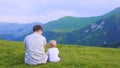 Happy mother and her child looking forward and pointing to sky. Family on trekking day in the mountains.