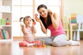 Happy mother and her child playing with colorful logical sorter toy