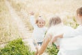 Happy mother and her children spending time together in sunny field Royalty Free Stock Photo