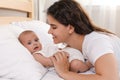 Happy young mother with her cute baby on bed at home Royalty Free Stock Photo