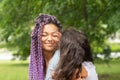 Happy mother with her daughter in her arms, african woman smiling, the child corrects the parent`s make-up and hair, family Royalty Free Stock Photo