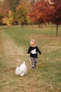 Happy mother and her daughter playing with dog in autumn park. Family, pet, domestic animal and lifestyle concept Royalty Free Stock Photo