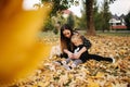 Happy mother and her daughter playing with dog in autumn park. Family, pet, domestic animal and lifestyle concept Royalty Free Stock Photo