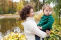 Happy mother and her little boy in the autumn park. Child playing with mother. Mother and son embracing Royalty Free Stock Photo