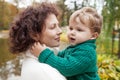 Happy mother and her little boy in the autumn park. Child playing with mother. Mother and son embracing Royalty Free Stock Photo