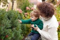 Happy mother and her little boy. Child playing with mother in the park. Mother and son embracing. Child studies a bush in the park Royalty Free Stock Photo