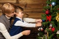 Happy mother and her lIttle boy decorating christmas tree Royalty Free Stock Photo