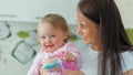 Happy mother and her little cheerful daughter playing at home