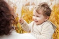 Happy mother and her little child in the park. Child playing with mother`s hair. Mother and son embracing Royalty Free Stock Photo