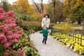 Happy mother and her little child walking in the park. Laughter mother and  son playing and runing in the garden. Autumn time Royalty Free Stock Photo