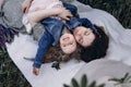 Happy mother and her little daughter in a field of lupins in summer. Mom hugs a happy baby