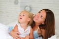 Happy mother and her little daughter lying in bed Royalty Free Stock Photo