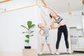 Focused mother and son doing side bends exercise, keeping fit