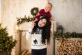 Happy mother and her little son are playing on background of the Christmas tree. Royalty Free Stock Photo