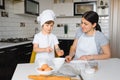 Happy mother and her little son shaking raw eggs in bowl before making dough for homemade pastry in the kitchen Royalty Free Stock Photo