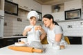 Happy mother and her little son shaking raw eggs in bowl before making dough for homemade pastry in the kitchen Royalty Free Stock Photo