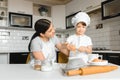 Happy mother and her little son shaking raw eggs in bowl before making dough for homemade pastry in the kitchen Royalty Free Stock Photo