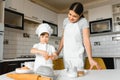 Happy mother and her little son shaking raw eggs in bowl before making dough for homemade pastry in the kitchen Royalty Free Stock Photo