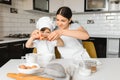 Happy mother and her little son shaking raw eggs in bowl before making dough for homemade pastry in the kitchen Royalty Free Stock Photo