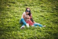 Happy mother with her little son sitting on grass in summer day Royalty Free Stock Photo