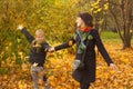 Happy mother and her son child boy having fun with fall leaves in autumn park Royalty Free Stock Photo