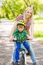 Happy mother with her son having fun, riding a bicycle Royalty Free Stock Photo