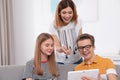 Happy mother, her teenager daughter and son with tablet Royalty Free Stock Photo