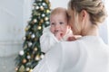 Happy mother with her young son on Christmas Eve near the Christmas tree Royalty Free Stock Photo