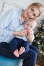 Happy mother with her young son on Christmas Eve near the Christmas tree Royalty Free Stock Photo