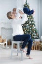 Happy mother with her young son on Christmas Eve near the Christmas tree Royalty Free Stock Photo